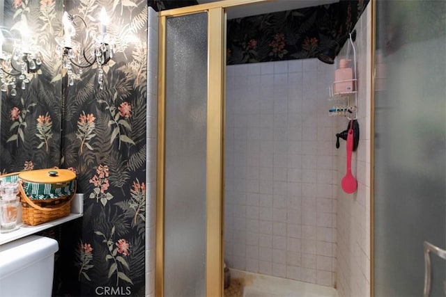 bathroom featuring a shower stall, toilet, and wallpapered walls