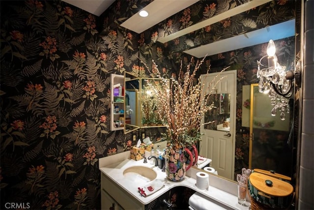 bathroom with vanity and wallpapered walls