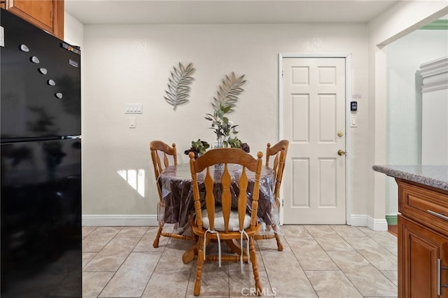 dining space with light tile patterned flooring and baseboards