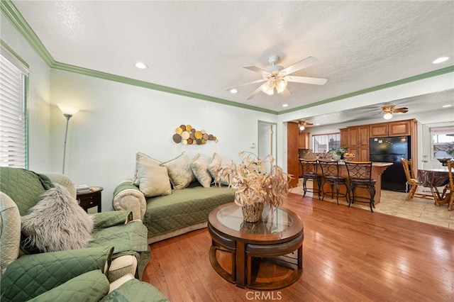 living area featuring a textured ceiling, light wood finished floors, and a wealth of natural light