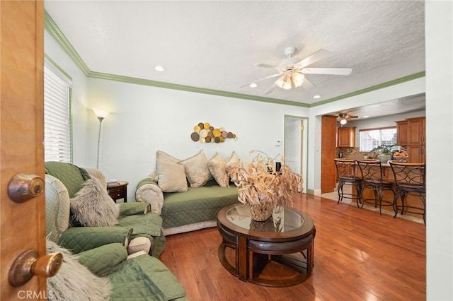 living area featuring ceiling fan, recessed lighting, wood finished floors, and crown molding