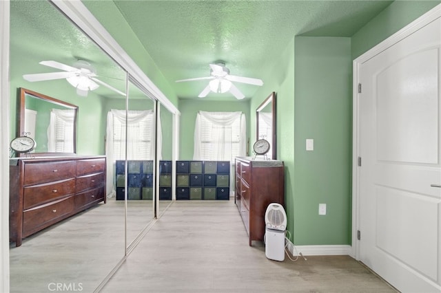 bedroom with a closet, ceiling fan, a textured ceiling, and wood finished floors