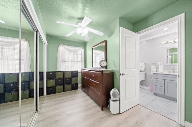 bathroom featuring ceiling fan, vanity, a textured ceiling, and wood finished floors