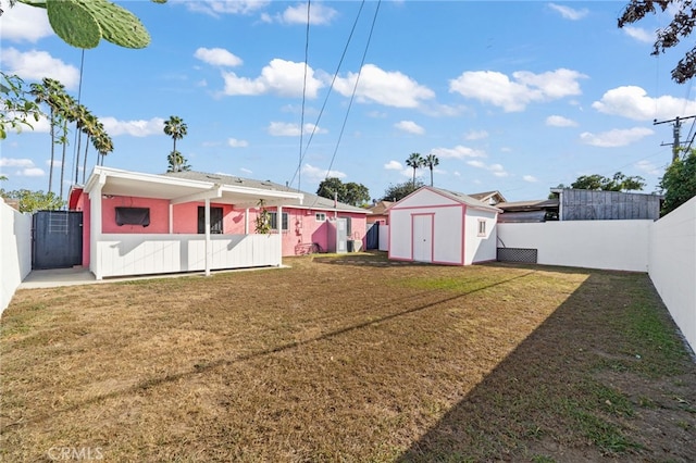 view of yard featuring a shed, an outdoor structure, and a fenced backyard