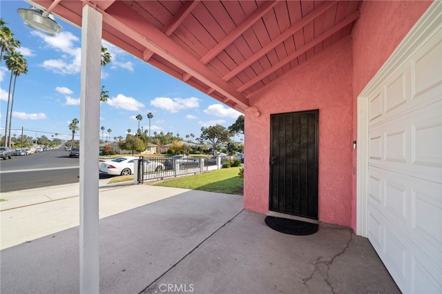 view of patio / terrace featuring a garage and fence