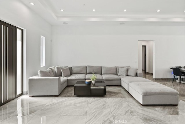 living area featuring marble finish floor, a raised ceiling, and recessed lighting