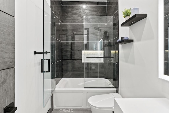 bathroom with toilet, bath / shower combo with glass door, and vanity