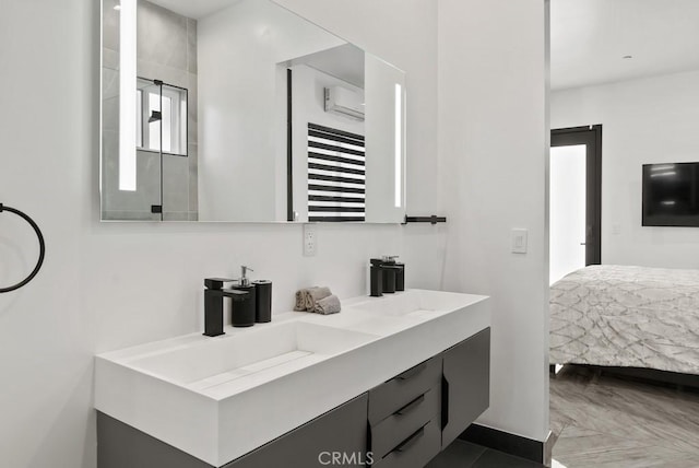 ensuite bathroom featuring double vanity, a sink, and connected bathroom