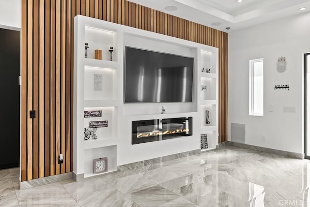 unfurnished living room featuring recessed lighting, visible vents, built in features, marble finish floor, and a glass covered fireplace