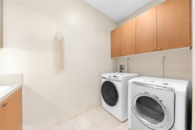 laundry room with separate washer and dryer, light tile patterned flooring, and cabinet space