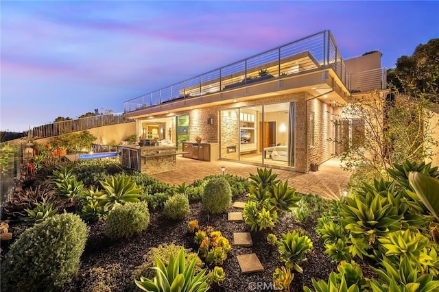 rear view of house featuring exterior kitchen, a patio area, and fence