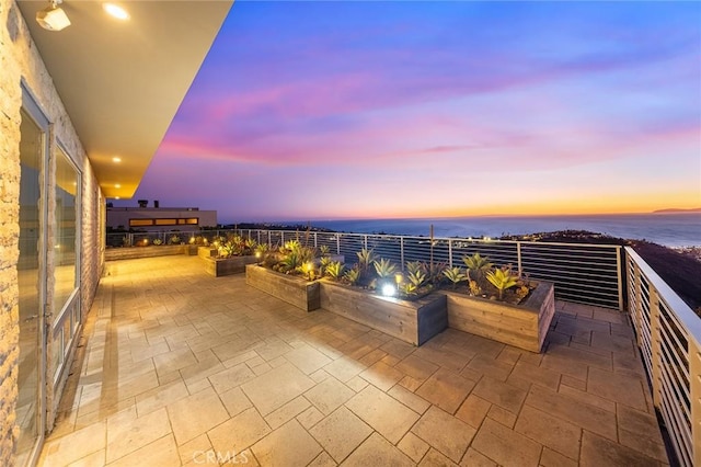 view of patio / terrace with a water view and a balcony