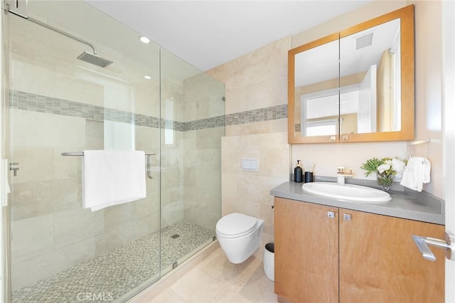 full bath featuring visible vents, toilet, vanity, a shower stall, and tile walls