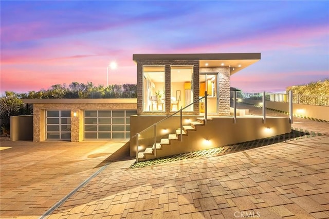 exterior space featuring decorative driveway and an attached garage