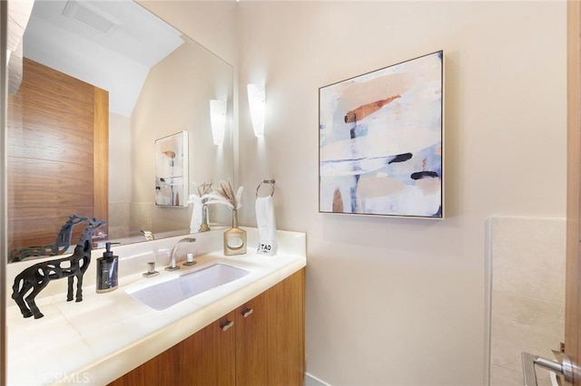 bathroom featuring vaulted ceiling and vanity