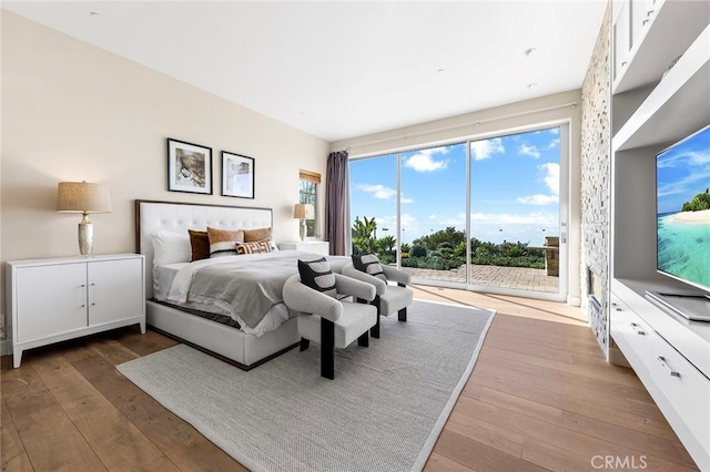 bedroom with access to exterior and light wood-type flooring