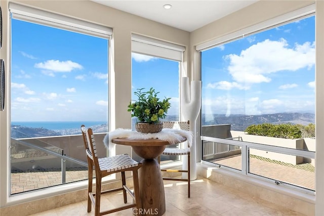 sunroom featuring a water view