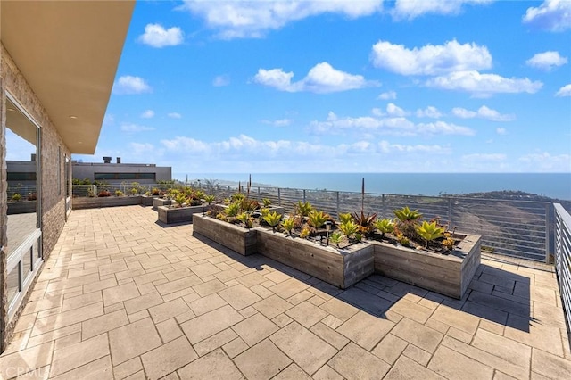 view of patio / terrace with a water view and fence