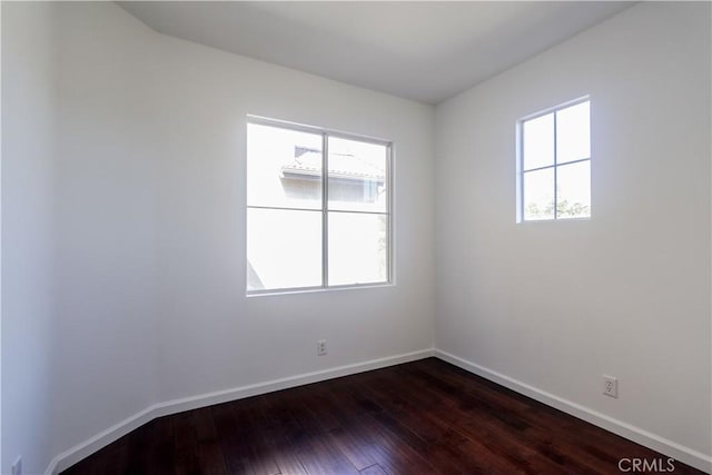 unfurnished room with dark wood finished floors and baseboards