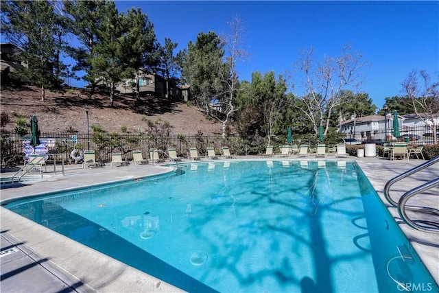 community pool featuring fence and a patio