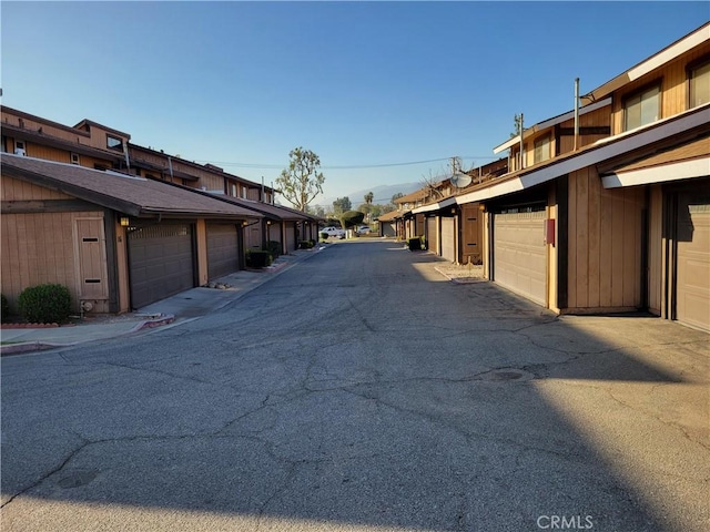 view of road featuring a residential view and community garages