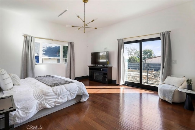 bedroom featuring an inviting chandelier, access to outside, and wood finished floors