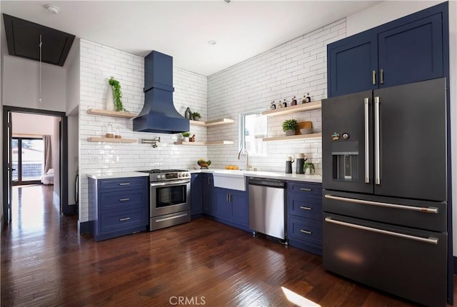 kitchen featuring stainless steel appliances, open shelves, light countertops, and custom range hood