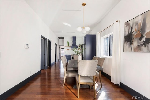 dining room with dark wood-style floors, a notable chandelier, and baseboards