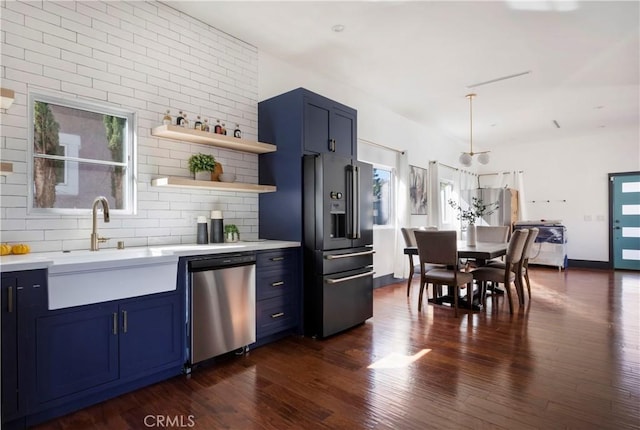 kitchen featuring appliances with stainless steel finishes, dark wood-type flooring, light countertops, blue cabinetry, and open shelves