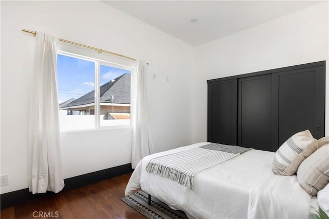 bedroom with dark wood-style floors