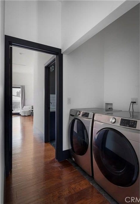 laundry room featuring laundry area, independent washer and dryer, and dark wood finished floors