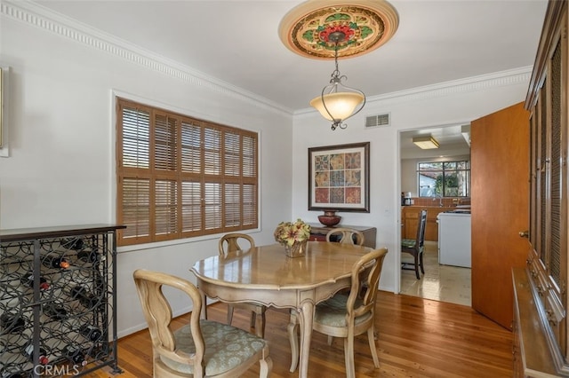 dining space featuring crown molding, visible vents, and wood finished floors