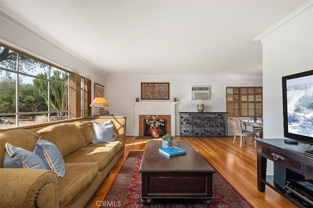 living room featuring wood finished floors, a wall mounted air conditioner, a fireplace with flush hearth, and crown molding