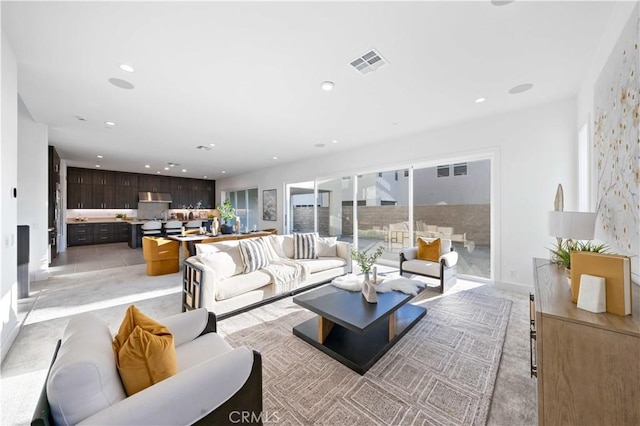 living area featuring visible vents and recessed lighting