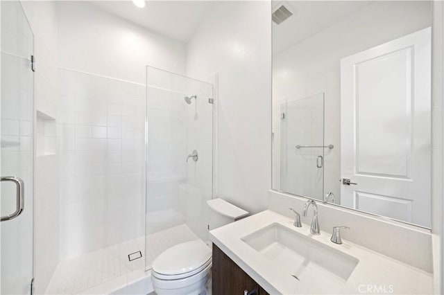 bathroom featuring toilet, a stall shower, visible vents, and vanity