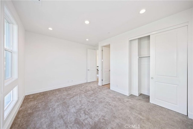 unfurnished bedroom with baseboards, carpet floors, multiple windows, and recessed lighting