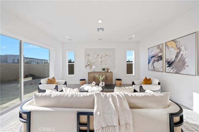 living area featuring recessed lighting, visible vents, and baseboards