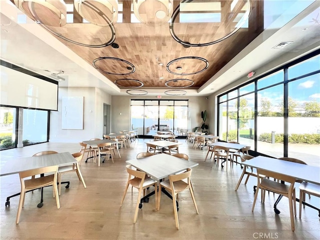 dining space with a tray ceiling, wooden ceiling, and visible vents