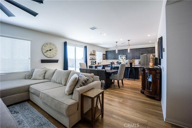 living room featuring recessed lighting, visible vents, and wood finished floors