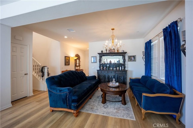 living room featuring a chandelier, stairway, wood finished floors, and recessed lighting