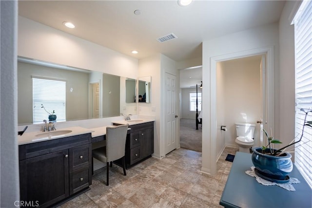 bathroom with visible vents, baseboards, toilet, vanity, and recessed lighting