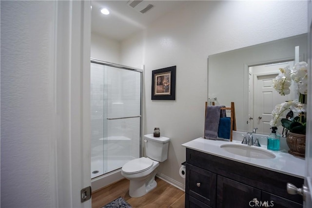 full bath with a stall shower, visible vents, toilet, wood finished floors, and vanity