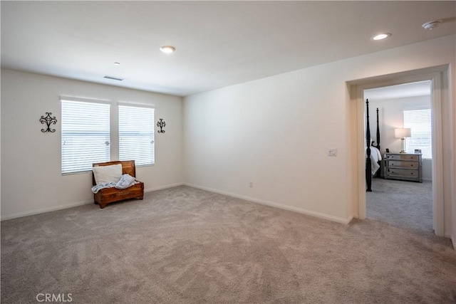 sitting room with baseboards, recessed lighting, visible vents, and light colored carpet