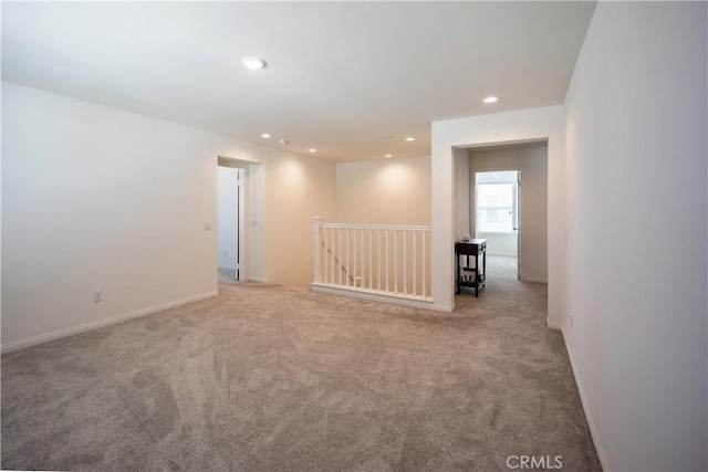 unfurnished room featuring baseboards, light colored carpet, and recessed lighting