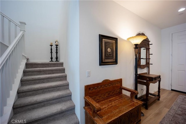 stairway with recessed lighting and wood finished floors