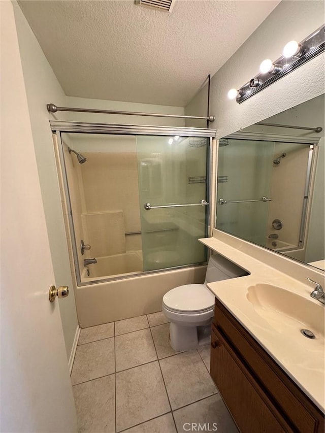 full bathroom with a textured ceiling, tile patterned flooring, toilet, bath / shower combo with glass door, and vanity