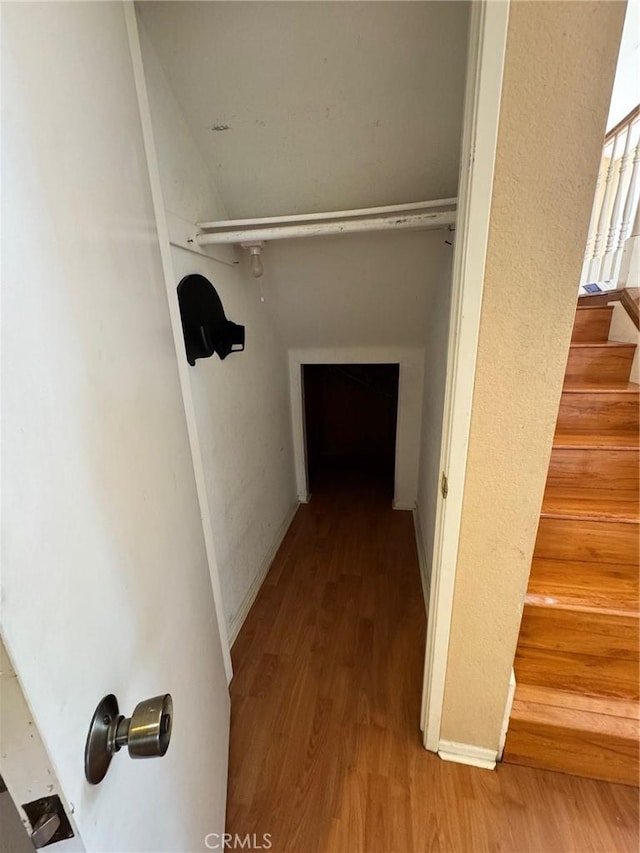 hallway featuring stairs, baseboards, and wood finished floors