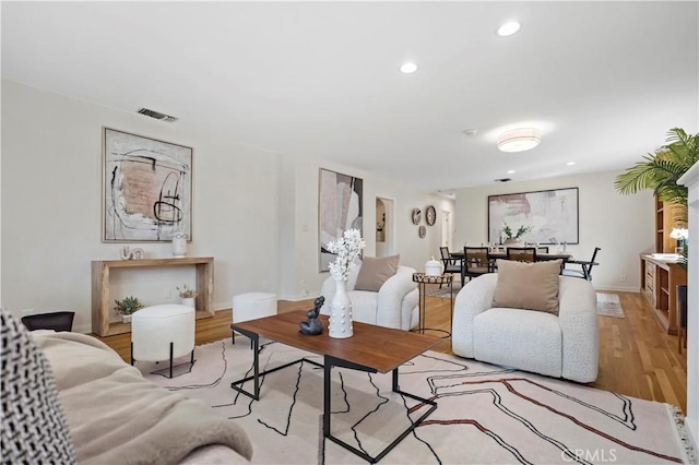 living room featuring recessed lighting, visible vents, and wood finished floors