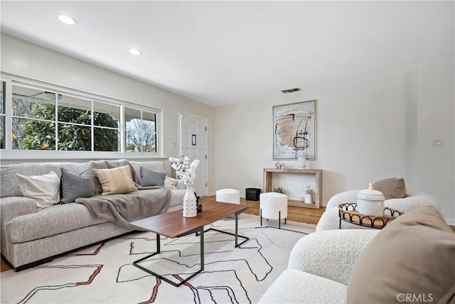 living room with wood finished floors, visible vents, and recessed lighting