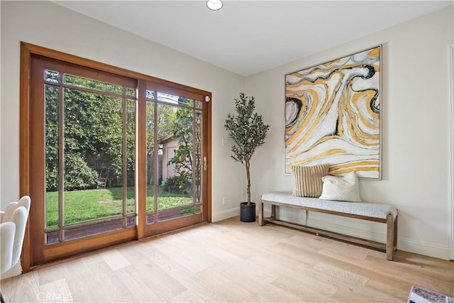 doorway featuring baseboards and wood finished floors